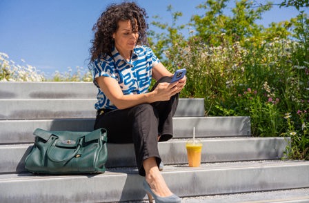 Dariana Kestenholz texting on her phone sitting on the stairs