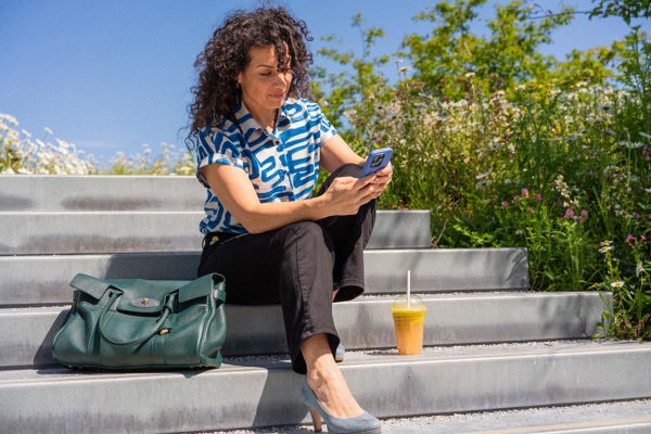 Dariana Kestenholz texting on her phone sitting on the stairs