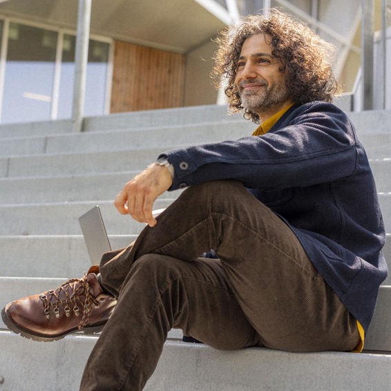 Ali Shah Ravn sitting on stairs working