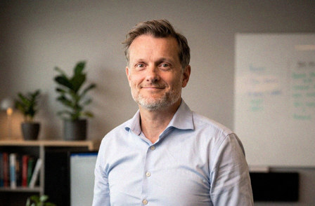 White male in light blue shirt standing in an office