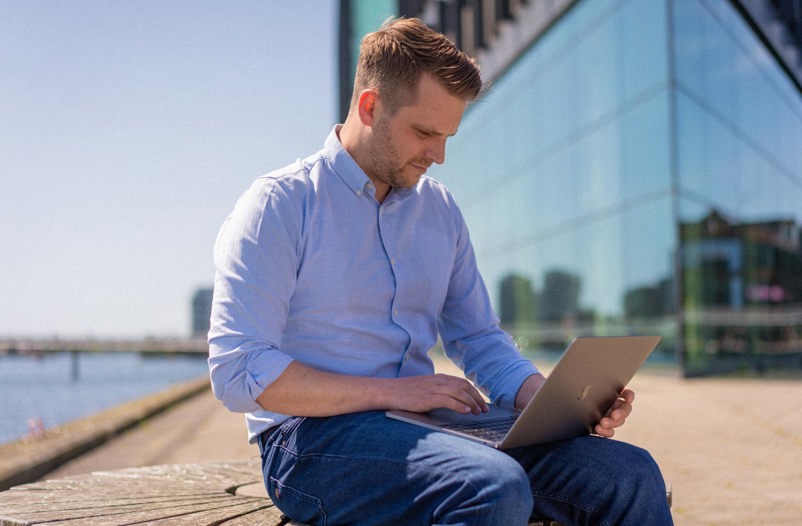 Man sitting outside working on a laptop