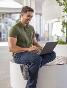 Antonio working on his laptop sitting outside