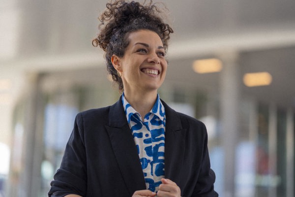 Woman with curly hair looking up and smiling